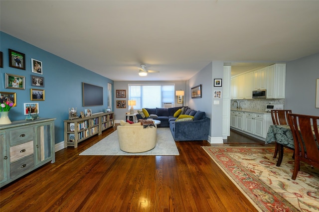 living room featuring ceiling fan, dark wood-type flooring, and sink