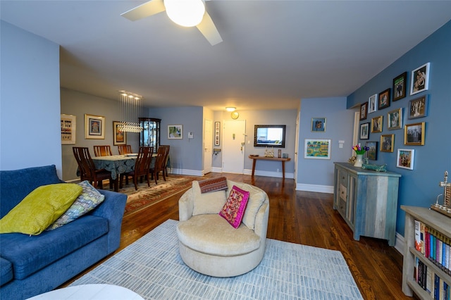 living room with dark hardwood / wood-style flooring and ceiling fan