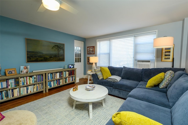 living room with ceiling fan, cooling unit, and hardwood / wood-style flooring