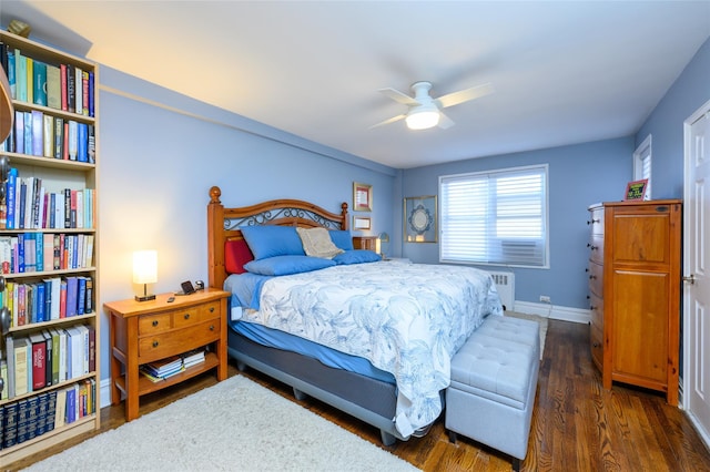 bedroom with ceiling fan, dark hardwood / wood-style floors, and radiator