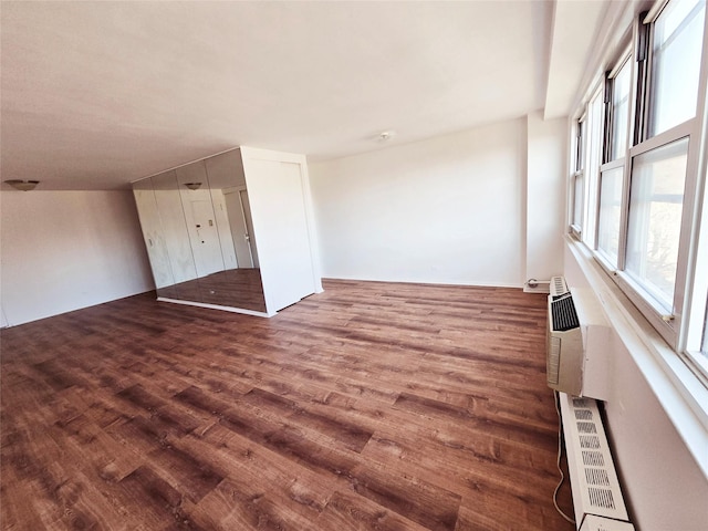 empty room with dark hardwood / wood-style floors and a wealth of natural light