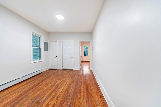 interior space featuring hardwood / wood-style flooring, electric panel, and a baseboard radiator