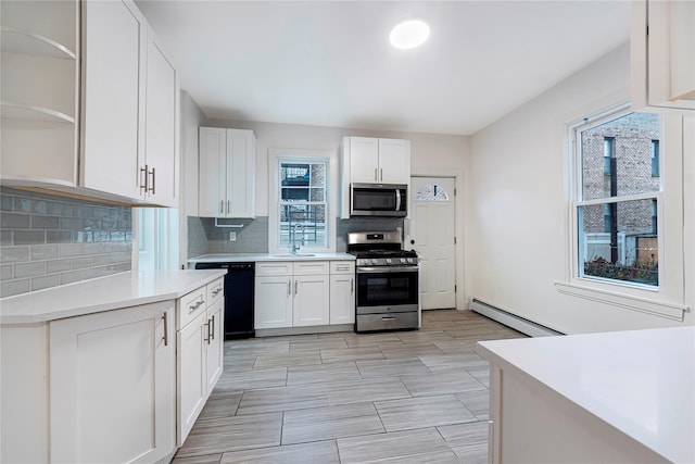 kitchen with sink, tasteful backsplash, white cabinetry, stainless steel appliances, and a baseboard radiator