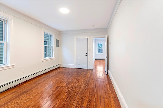 spare room featuring a wealth of natural light, dark wood-type flooring, and a baseboard radiator