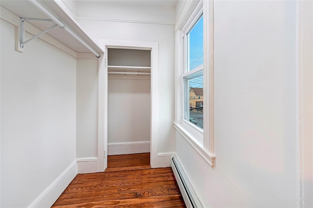 walk in closet with baseboard heating and dark wood-type flooring