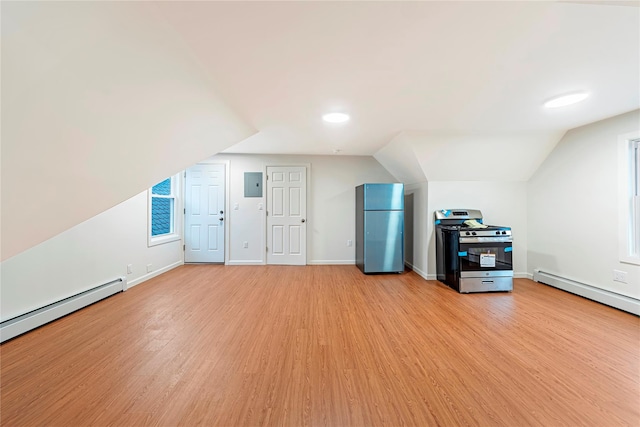 additional living space with light hardwood / wood-style floors, a baseboard radiator, and vaulted ceiling