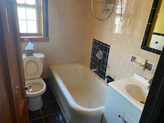 bathroom with tile patterned floors, vanity, toilet, and tile walls