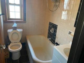 bathroom with vanity, toilet, and tile walls