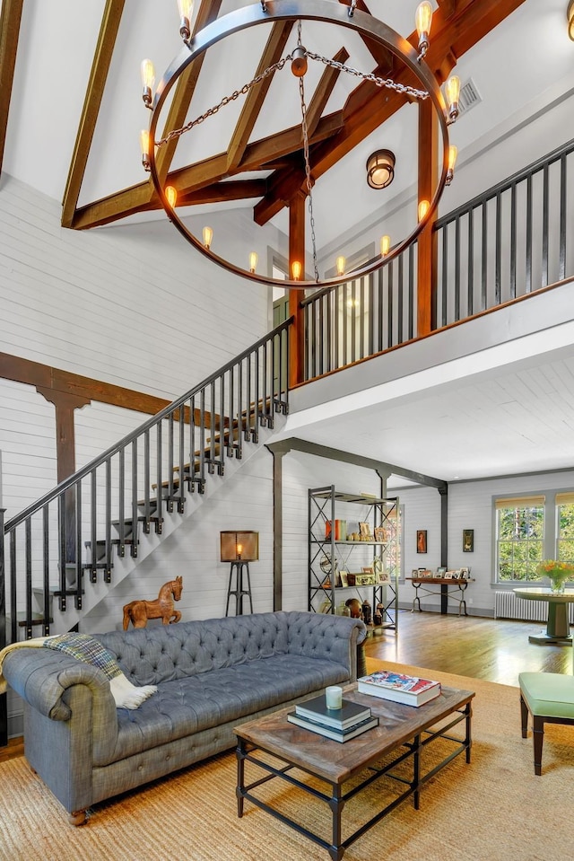 living room with an inviting chandelier, radiator, high vaulted ceiling, and hardwood / wood-style flooring