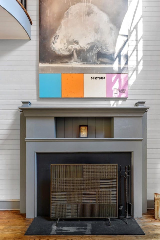 room details featuring wooden walls, hardwood / wood-style floors, and a fireplace