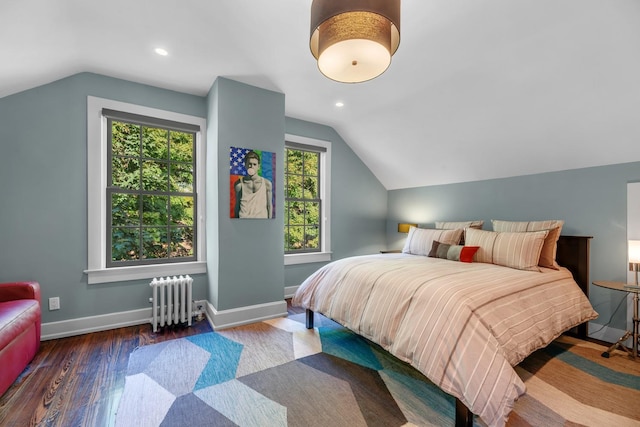 bedroom with dark wood-type flooring, radiator, and vaulted ceiling