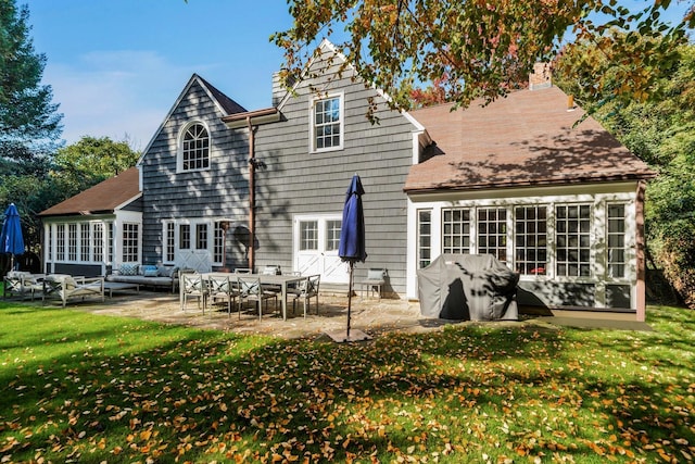 back of house featuring a patio area, outdoor lounge area, and a lawn