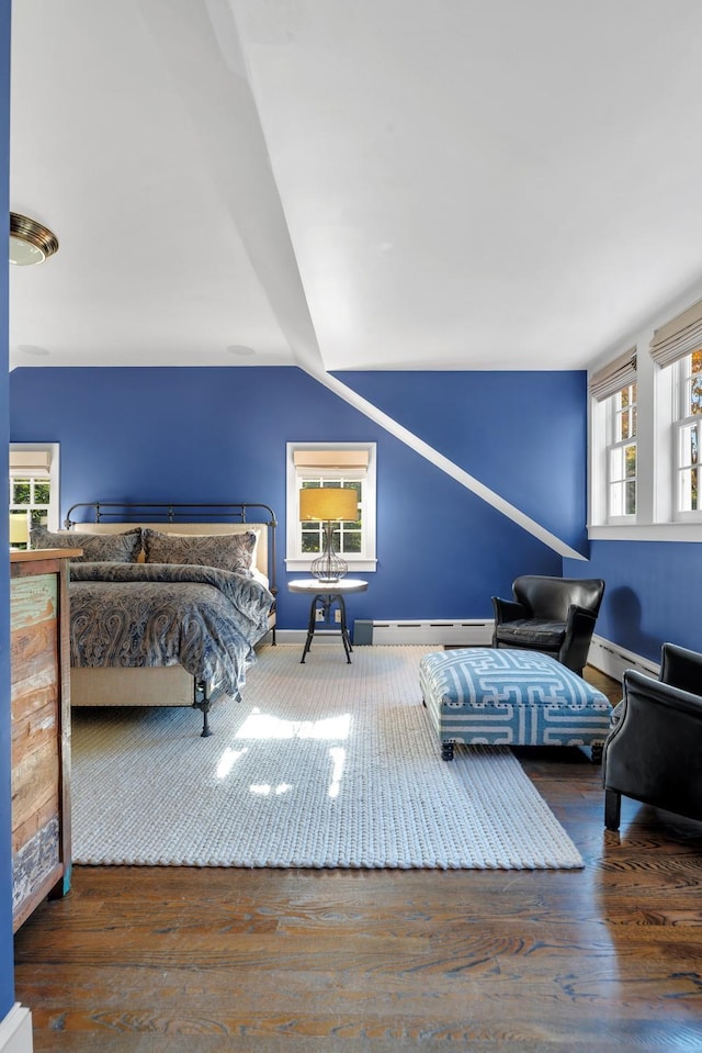 bedroom with vaulted ceiling, a baseboard heating unit, and dark hardwood / wood-style floors