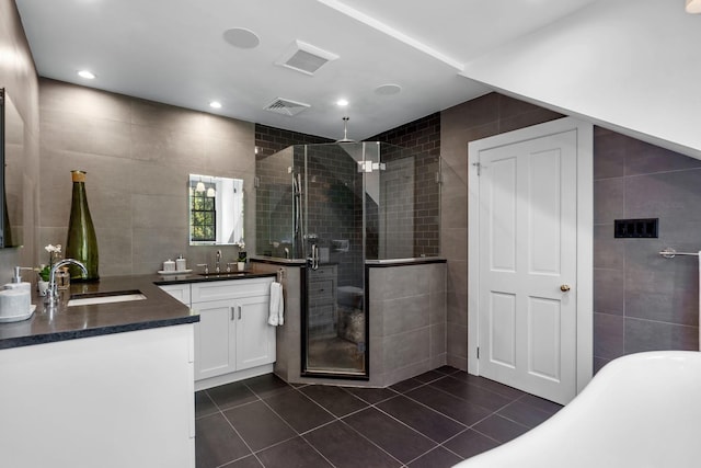 bathroom featuring tile walls, vanity, tile patterned floors, and plus walk in shower