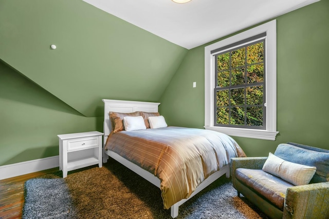 bedroom featuring vaulted ceiling and dark wood-type flooring