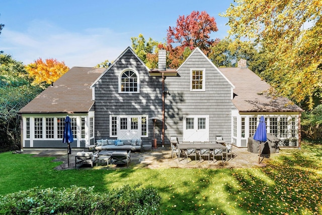 rear view of house featuring an outdoor living space, a patio, and a lawn