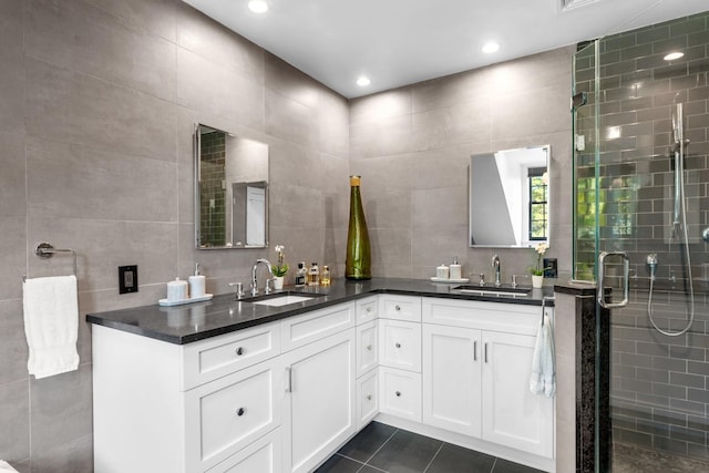 bathroom with tile walls, backsplash, vanity, tile patterned floors, and walk in shower