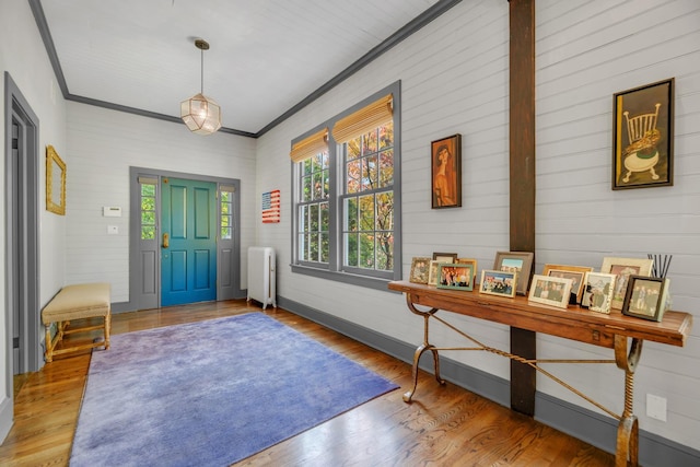 entryway featuring radiator, crown molding, and hardwood / wood-style floors