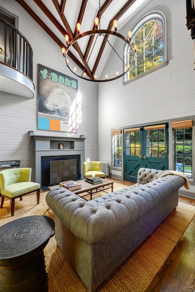 living room with beamed ceiling, high vaulted ceiling, hardwood / wood-style floors, and an inviting chandelier