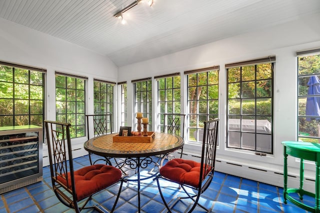 sunroom / solarium with a baseboard heating unit, vaulted ceiling, and rail lighting