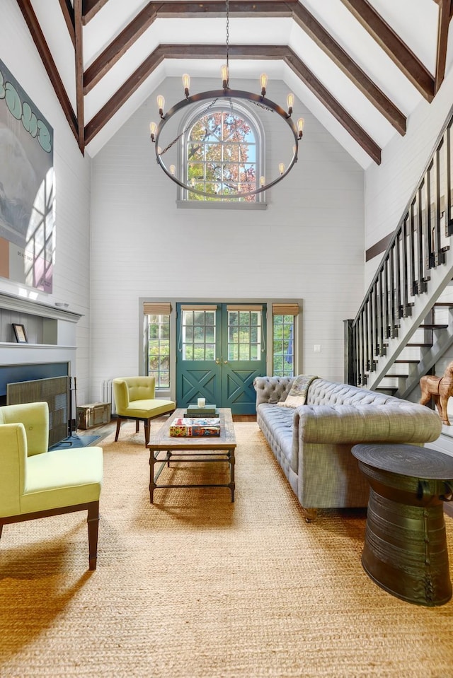 living room featuring beamed ceiling, plenty of natural light, a notable chandelier, and high vaulted ceiling