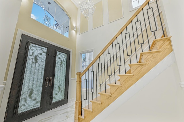 entryway featuring a chandelier, french doors, and a high ceiling