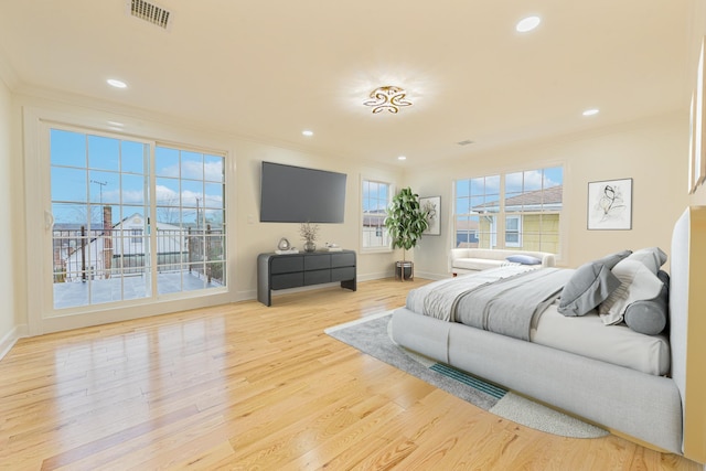 bedroom with crown molding and light hardwood / wood-style floors