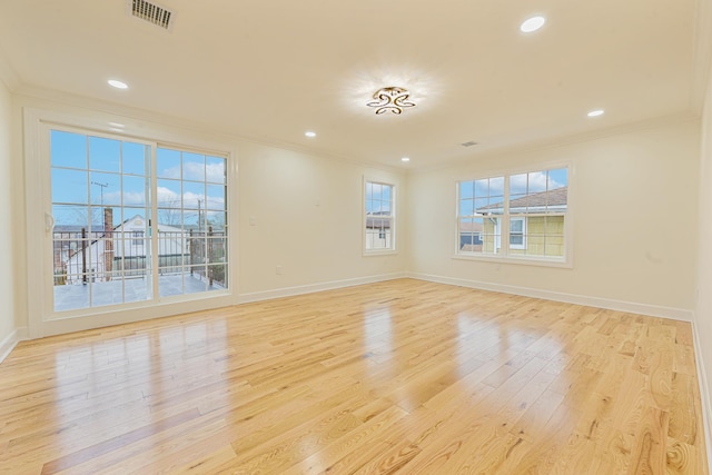 empty room with ornamental molding and light hardwood / wood-style flooring