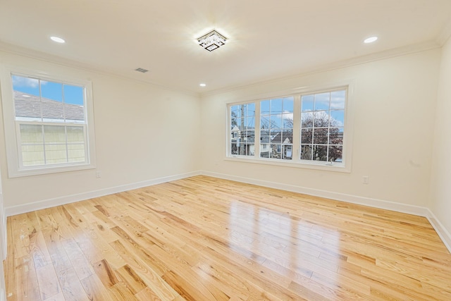 unfurnished room featuring light hardwood / wood-style floors, crown molding, and a healthy amount of sunlight