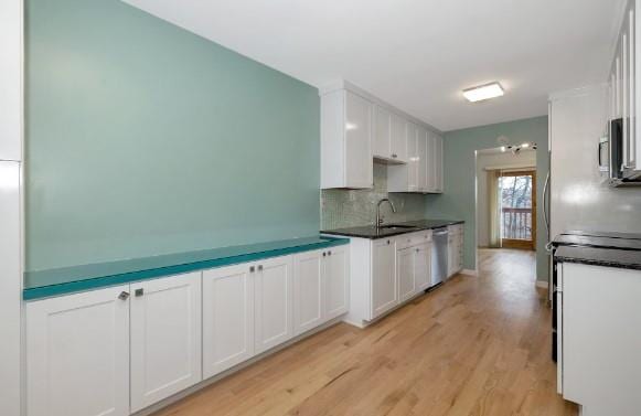 kitchen featuring stainless steel appliances, sink, and white cabinets