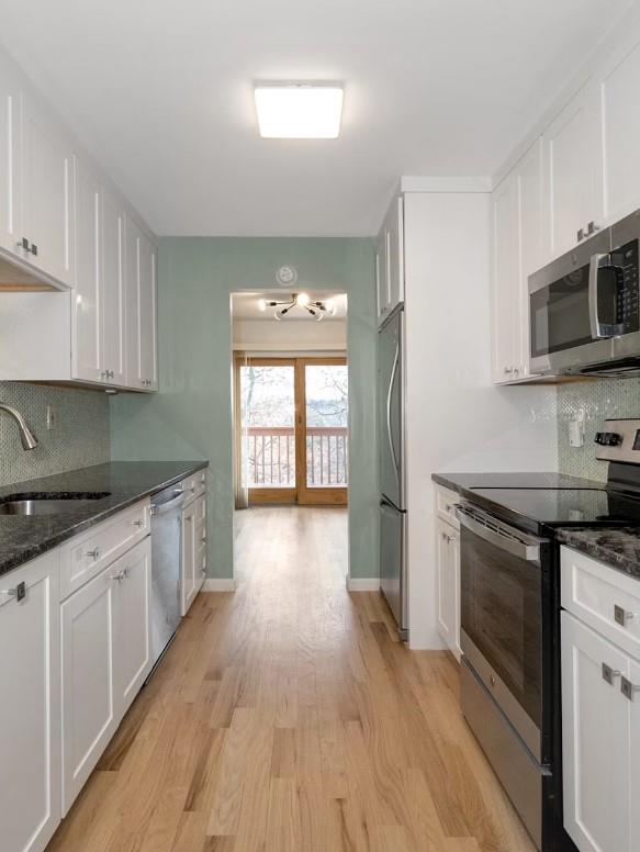 kitchen featuring sink, light hardwood / wood-style flooring, stainless steel appliances, and white cabinets