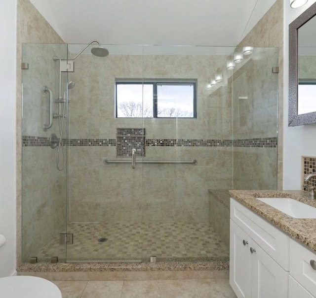 bathroom featuring vanity, toilet, tile patterned floors, and walk in shower