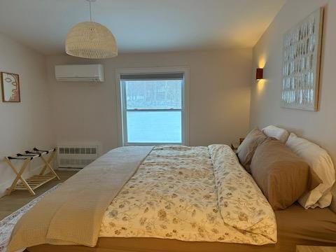 bedroom featuring an AC wall unit and radiator heating unit