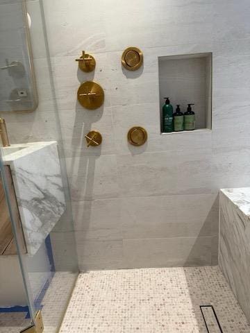 bathroom featuring tile patterned flooring and a tile shower