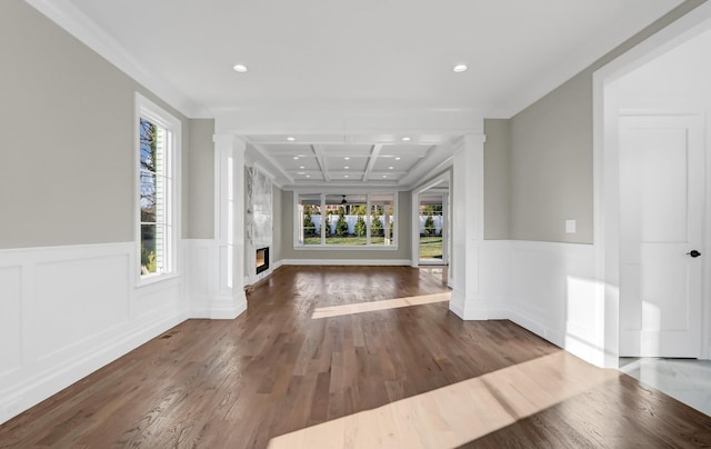 unfurnished living room featuring beamed ceiling, wood-type flooring, crown molding, and coffered ceiling