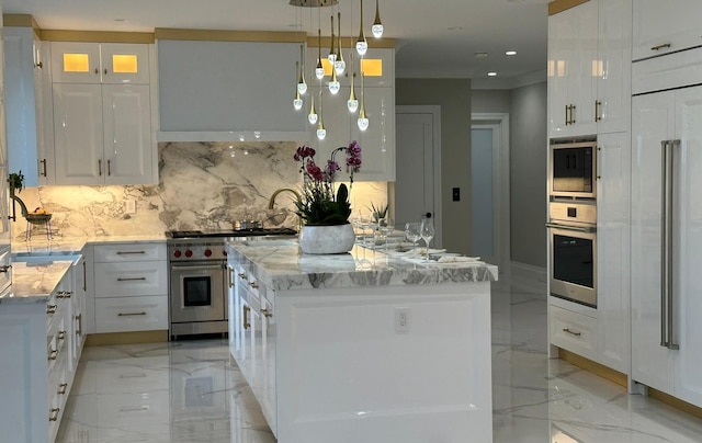 kitchen featuring backsplash, stainless steel appliances, white cabinets, a kitchen island, and hanging light fixtures