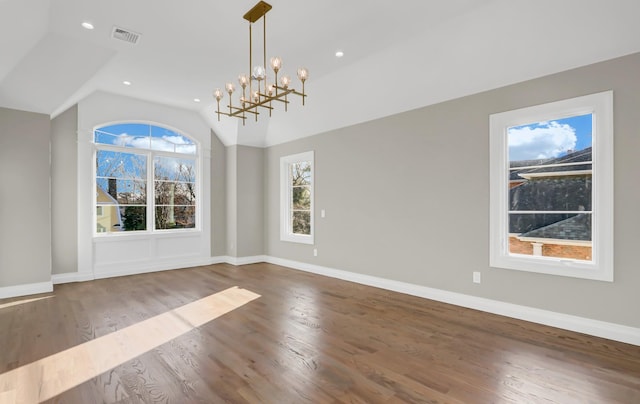 unfurnished dining area featuring hardwood / wood-style floors, lofted ceiling, and an inviting chandelier