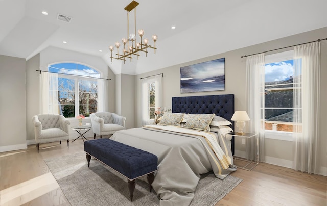 bedroom with a chandelier, lofted ceiling, and light hardwood / wood-style flooring