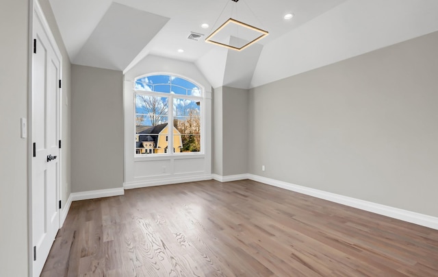 unfurnished bedroom featuring wood-type flooring and vaulted ceiling