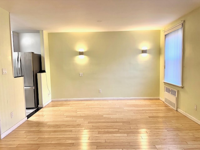 spare room featuring light hardwood / wood-style floors and radiator heating unit