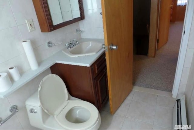 bathroom featuring baseboard heating, tasteful backsplash, toilet, vanity, and tile walls