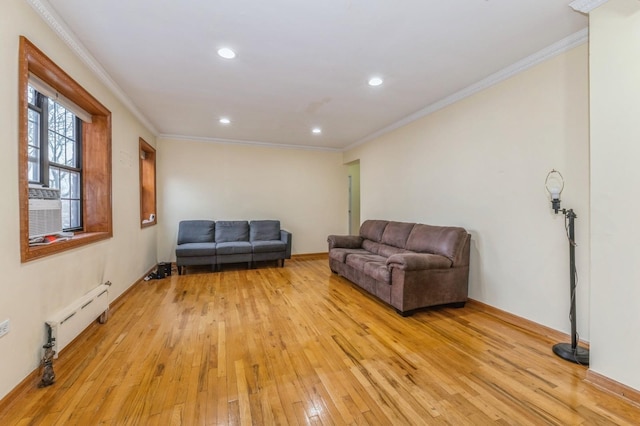 living room with baseboard heating, cooling unit, light hardwood / wood-style floors, and ornamental molding