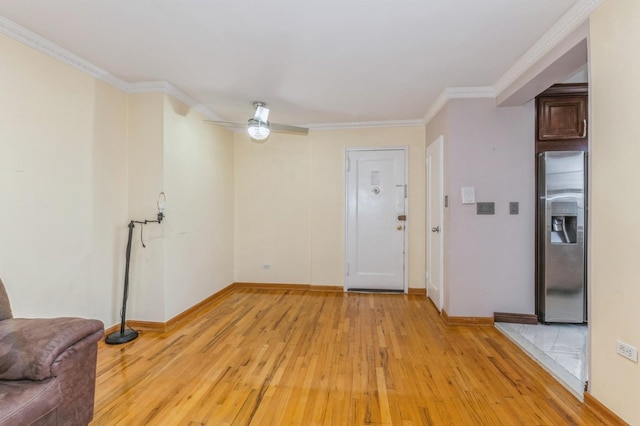 empty room with ceiling fan, ornamental molding, and light wood-type flooring