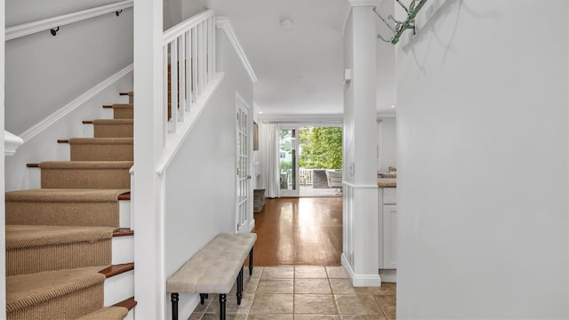 foyer featuring light tile patterned floors and ornamental molding