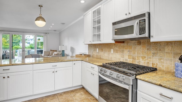 kitchen with decorative light fixtures, crown molding, white cabinetry, light stone countertops, and appliances with stainless steel finishes