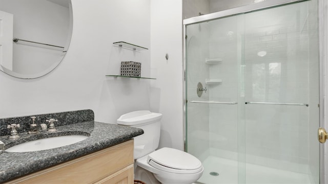 bathroom featuring toilet, an enclosed shower, and vanity