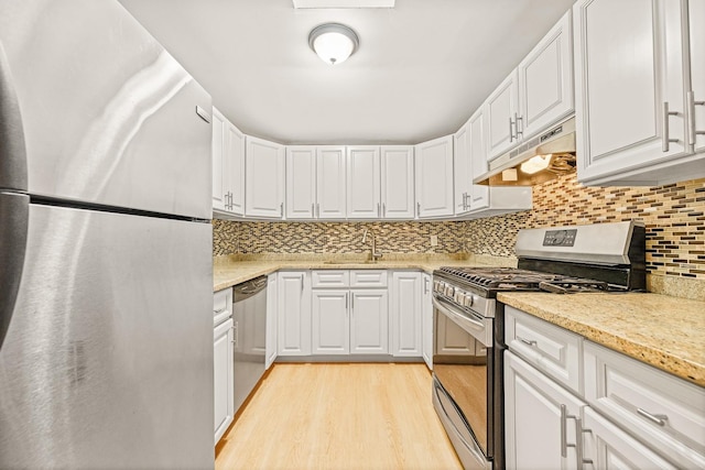 kitchen featuring white cabinets, light hardwood / wood-style floors, custom range hood, and stainless steel appliances