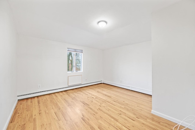 spare room featuring light wood-type flooring and baseboard heating