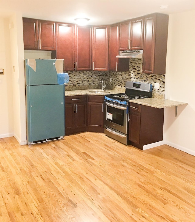 kitchen with backsplash, sink, light hardwood / wood-style flooring, kitchen peninsula, and stainless steel appliances