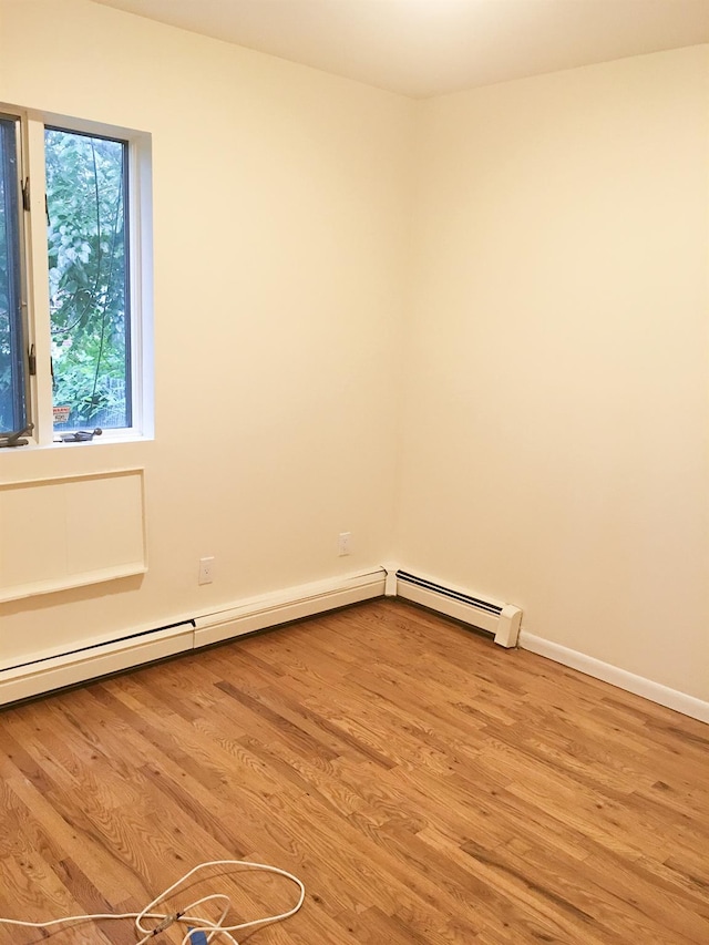 spare room featuring hardwood / wood-style flooring and a baseboard radiator